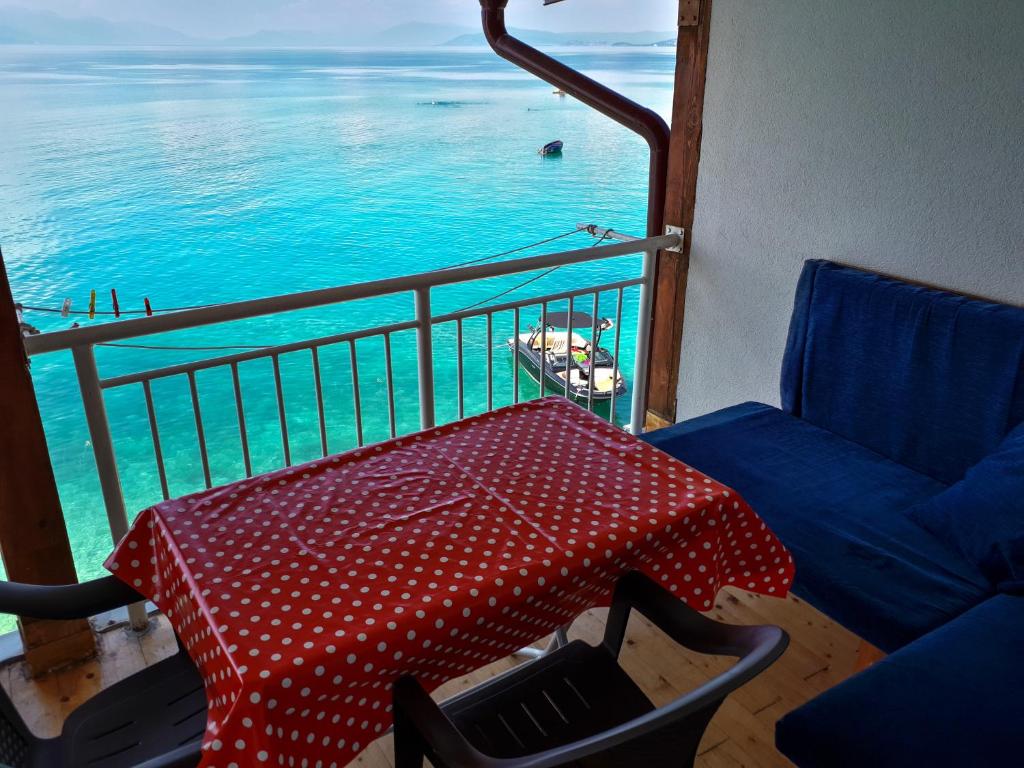 特佩杰卡Villa Bube的阳台配有桌子和遮阳伞,享有海景。