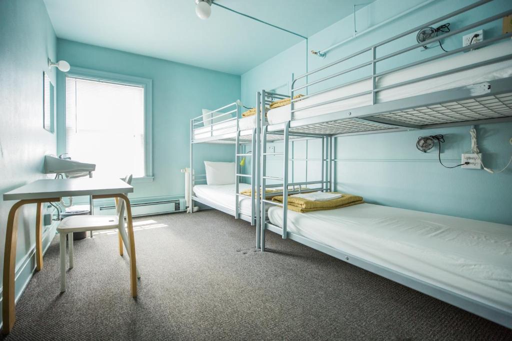 西雅图American Hotel Hostel的客房设有两张双层床和一张书桌。