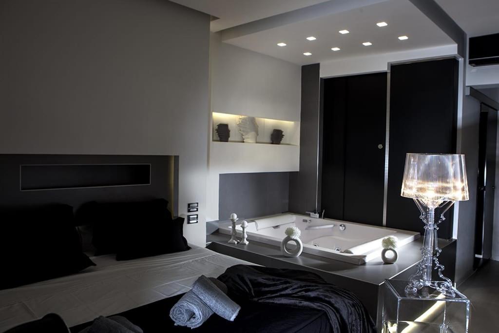 那不勒斯Crystal skyline neapolis的带浴缸的浴室以及带台灯的床。