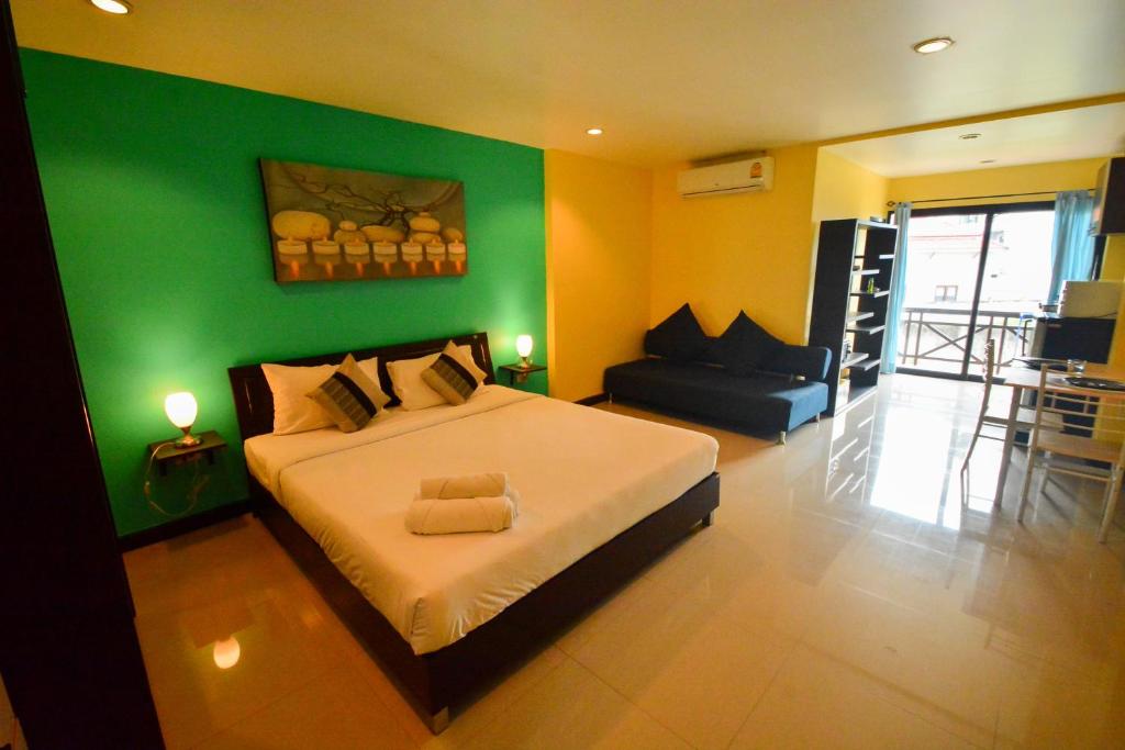 波普托壁虎酒店的一间卧室设有一张大床和绿色的墙壁