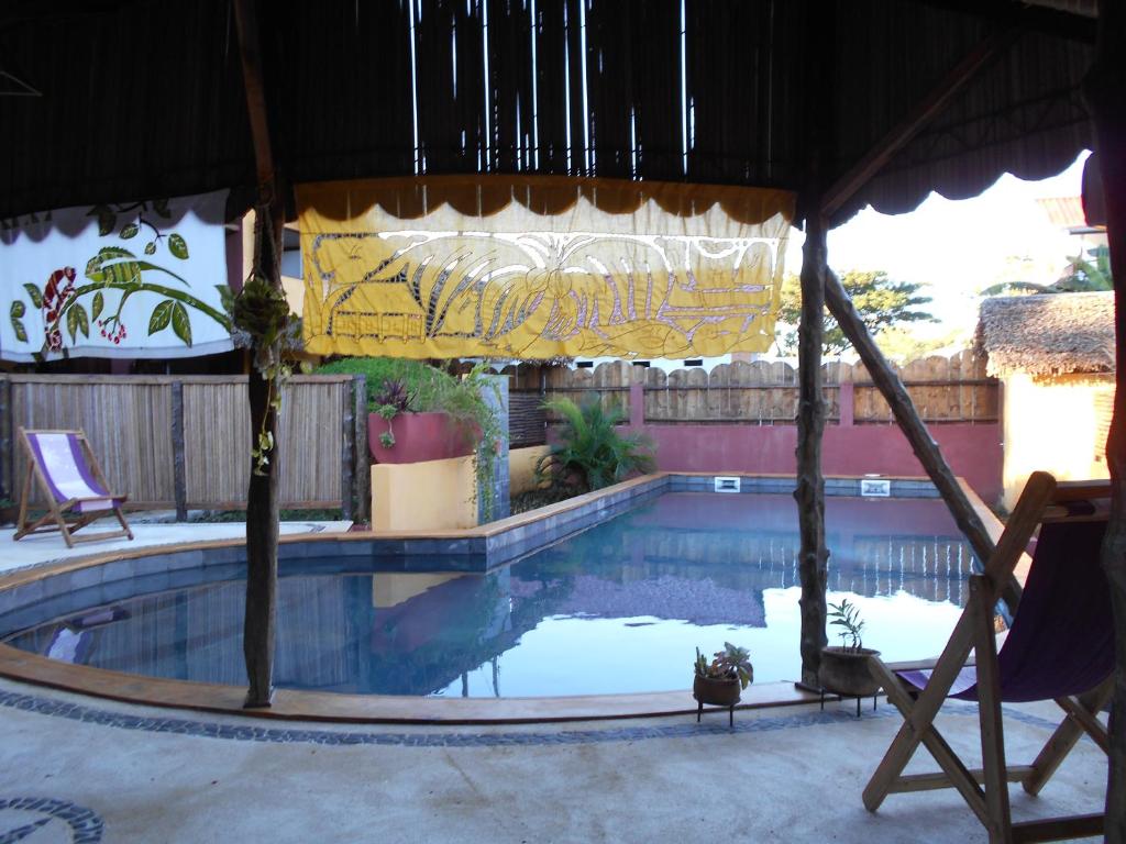贝岛Hotel Ambalamanga的一个带椅子和遮阳伞的游泳池