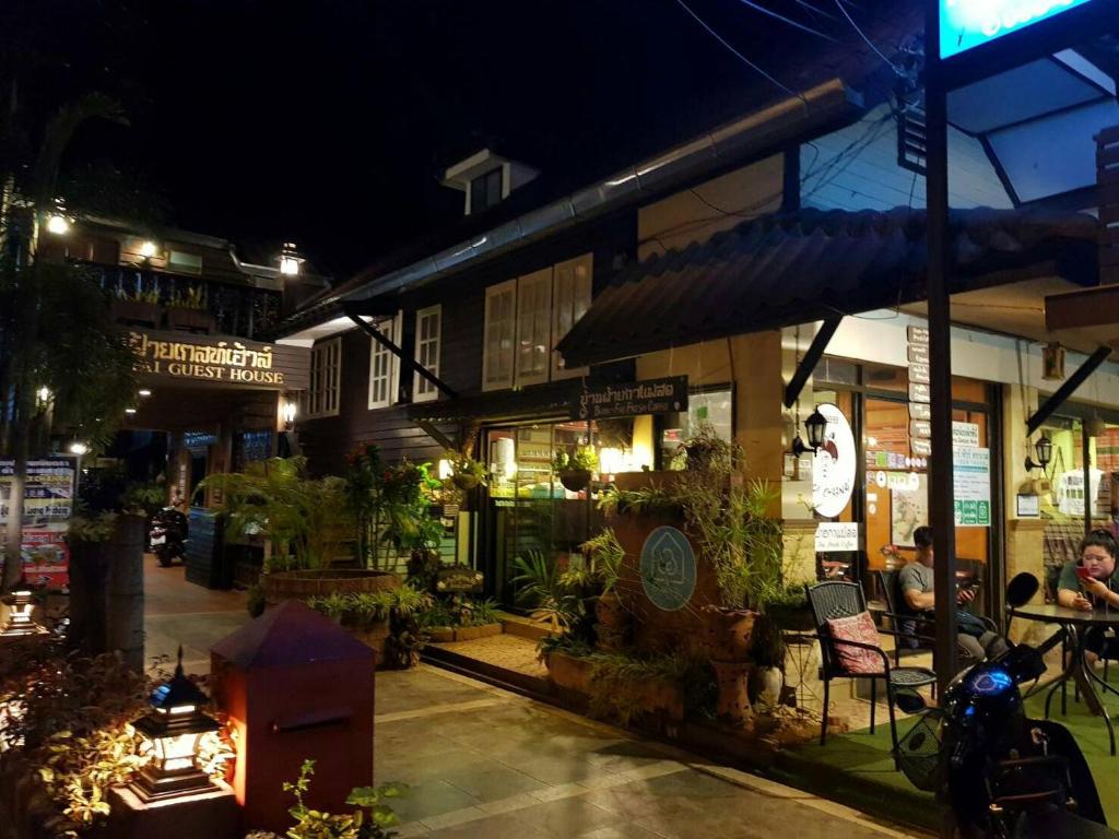清孔Baanfai Guesthouse Chiangkhong的一群人晚上坐在建筑物外面