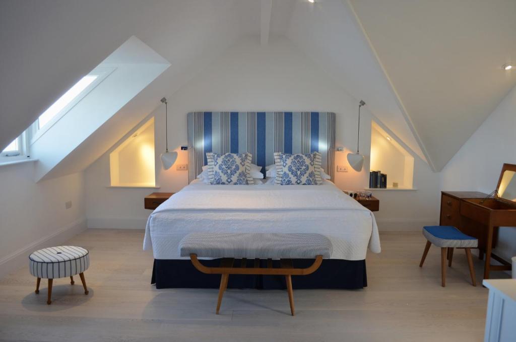 圣艾夫斯特雷弗斯港口宾馆的一间卧室配有一张带蓝白色枕头的大床