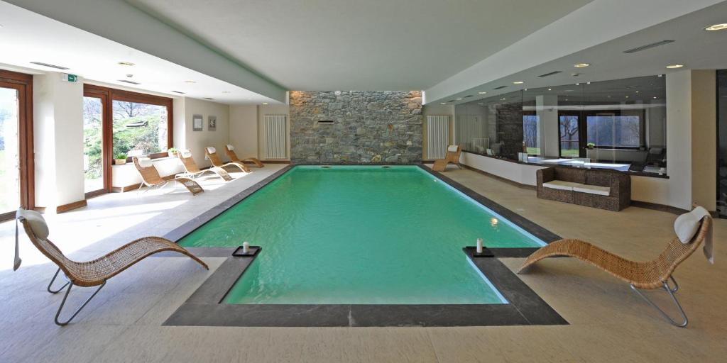 安泰伊-萨伊恩特-安德尔埃蒂斯尔庄园酒店的一个带椅子和石墙的大型游泳池