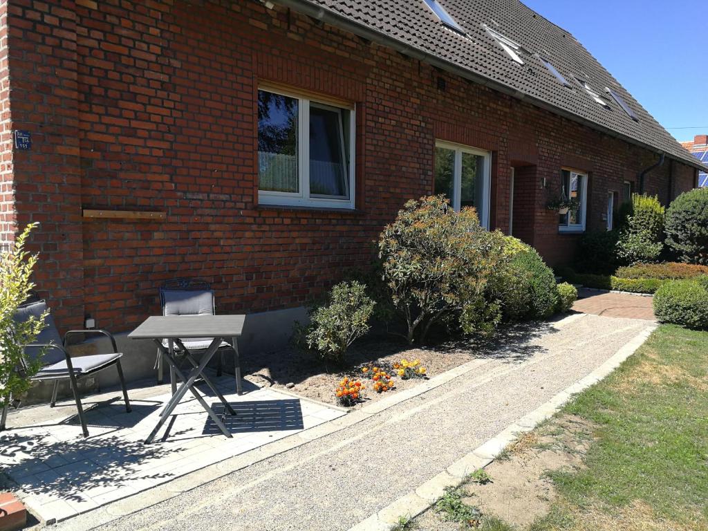 拉德贝尔根Ferienwohnung Gravemeier的砖屋前的桌子和椅子