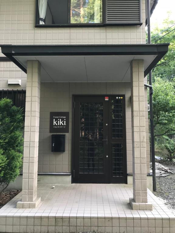富士吉田市Forest Cottage kiki的进入带黑色门的建筑物的入口