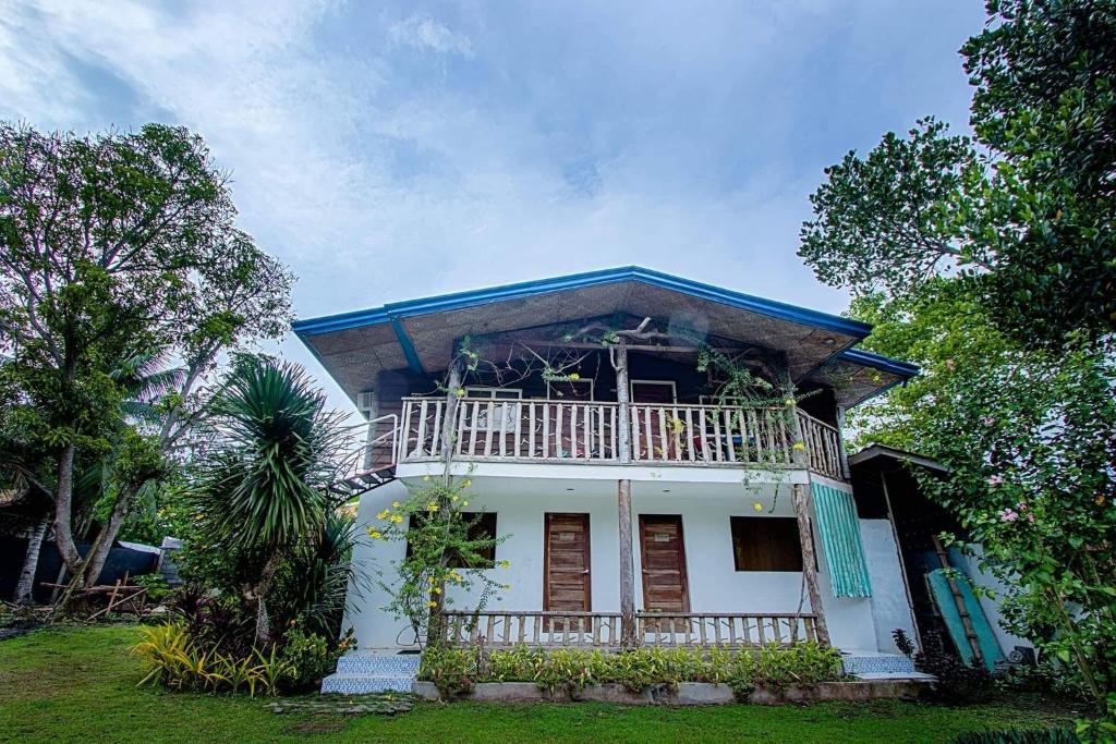 萨马尔La Vida Hostel Samal Island的白色的房子,上面设有阳台