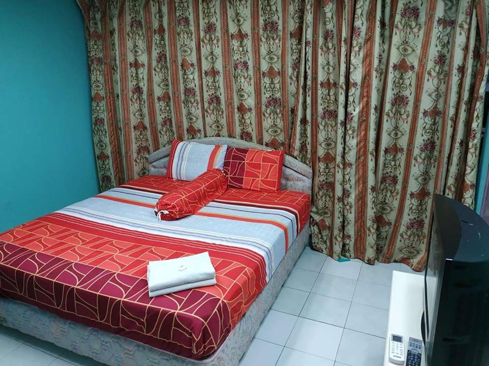 马六甲古城酒店的一张带红色棉被的床和一本书