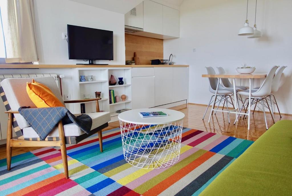 卡鲁德杰尔斯科巴尔Apartments Milic的客厅配有桌子和多彩的地毯