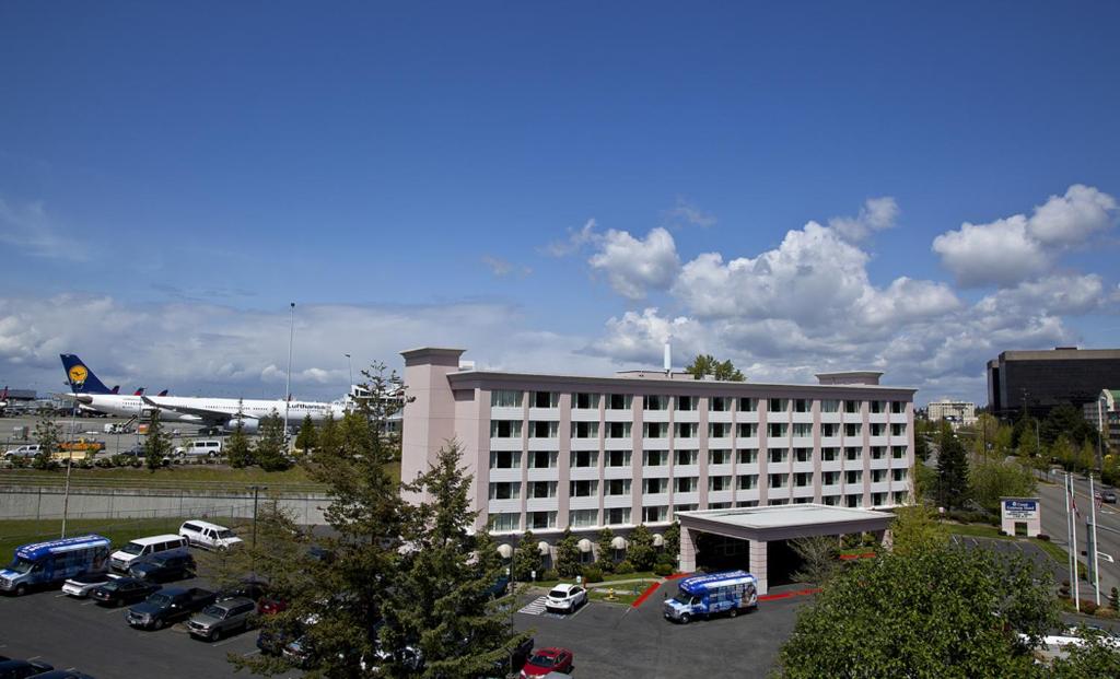 西塔科海岸门户酒店的一座大型建筑,设有停车场和飞机