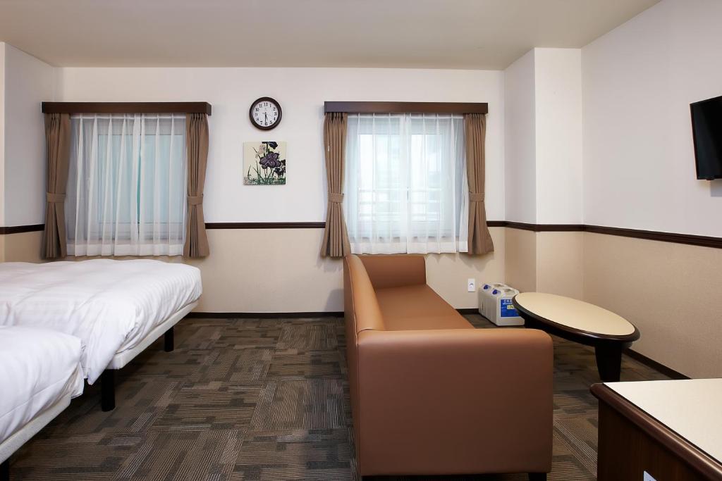 首尔Toyoko Inn Seoul Gangnam的酒店客房,设有两张床和一张沙发