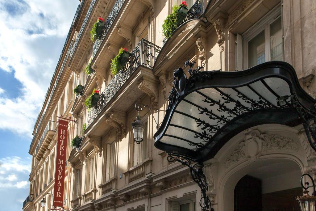 巴黎巴黎梅费尔酒店的建筑的一边有长凳