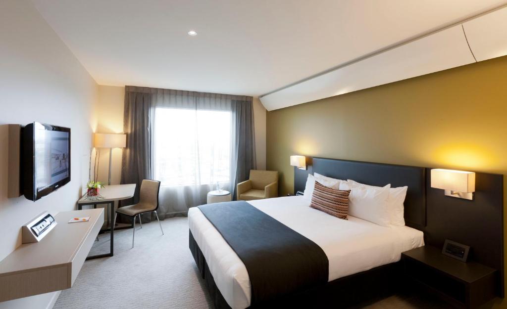 奥克兰苏迪马酒店的酒店客房设有一张大床和一张书桌。