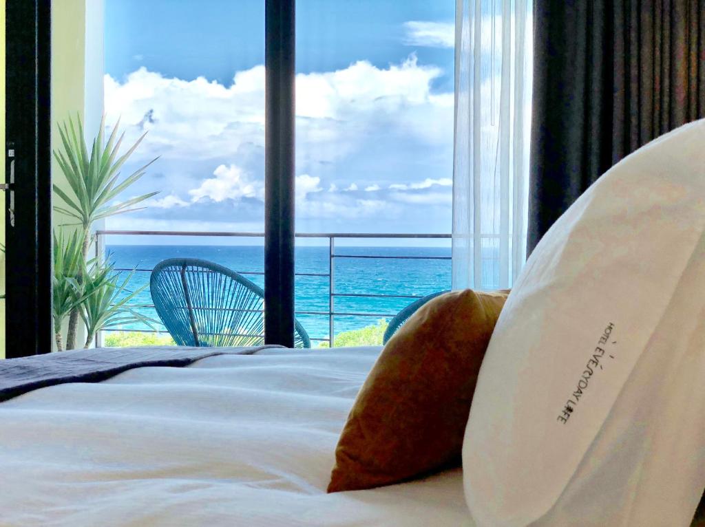 鹅銮鼻美好生活旅店的一间卧室设有一张床,享有海景