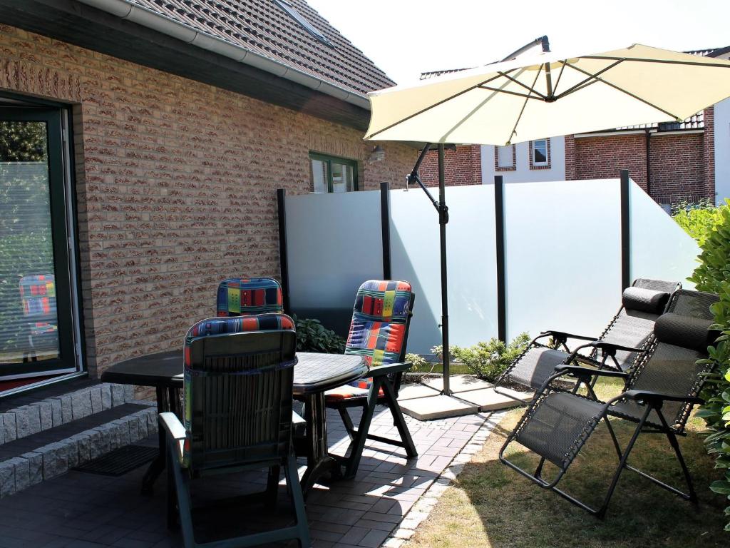 博尔滕哈根Modern Apartment near Sea in Ostseebad Boltenhagen的庭院配有桌椅和遮阳伞。