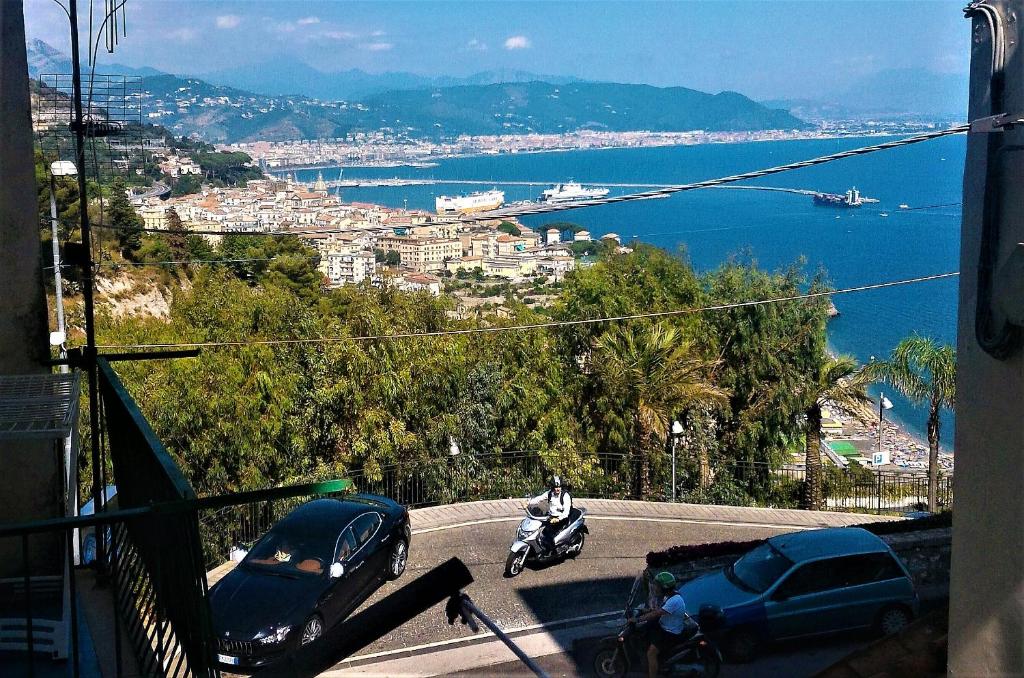 维耶特里LA SCALINATELLA -vista mare-的骑摩托车在水边的路上的人
