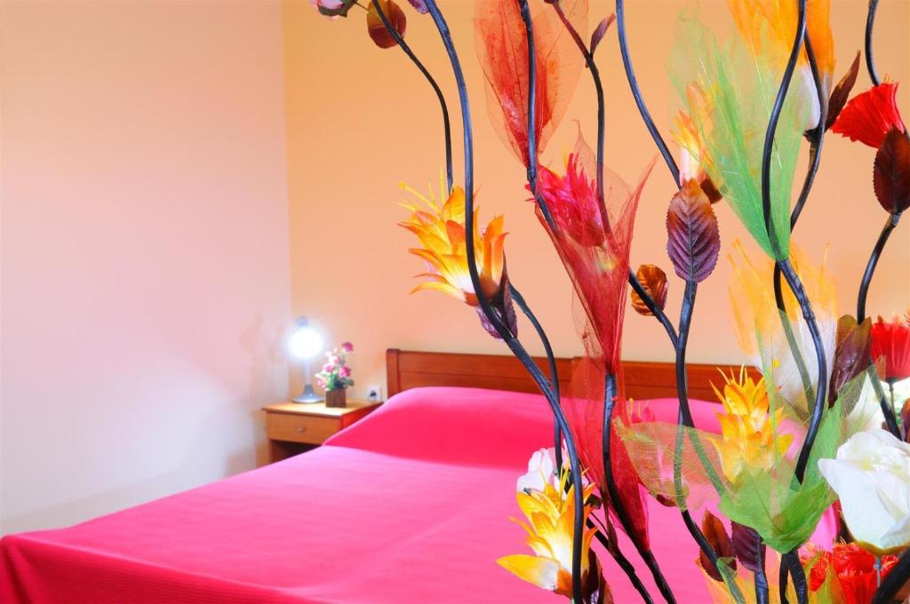 卡尔扎迈纳尼科斯2一室公寓的一间卧室配有一张粉红色的床和花墙