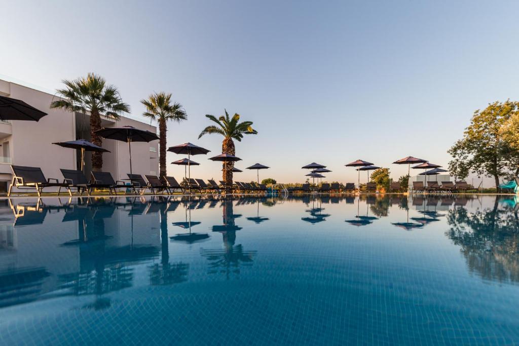 帕拉利亚卡泰里尼斯Mythic Summer Hotel的一个带遮阳伞和椅子的大型游泳池
