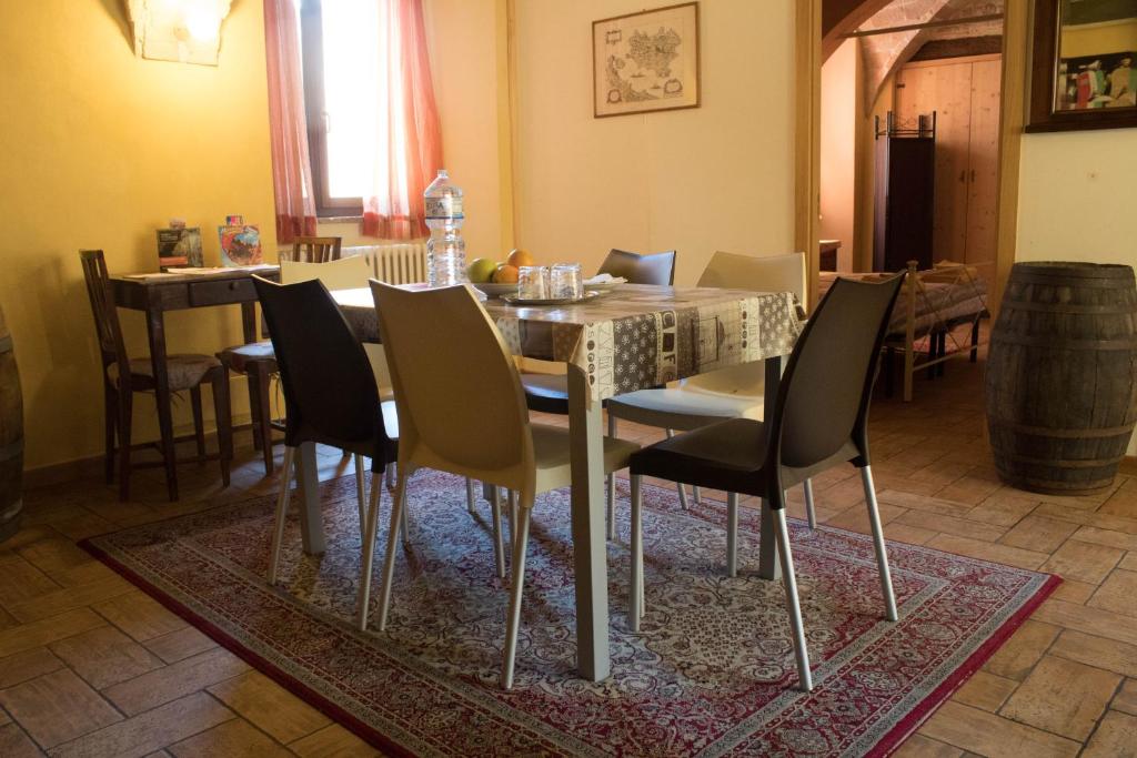 CupramontanaLo Sfizio B&B的一间位于地毯上的带桌椅的用餐室