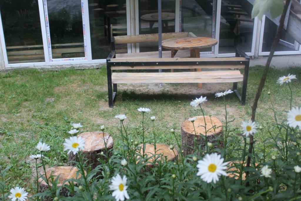 博尔若米Borjomi Makvala's Guest House的院子里的长凳,花朵和桌子