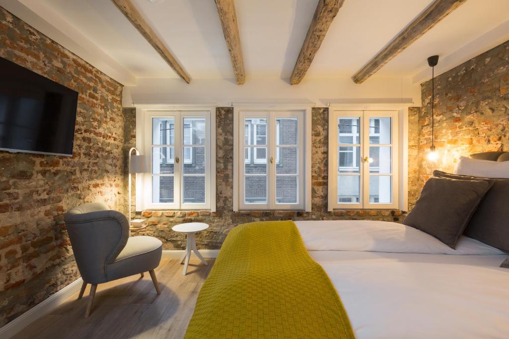 杜塞尔多夫20号广场公寓的一间卧室配有一张床、一把椅子和窗户。