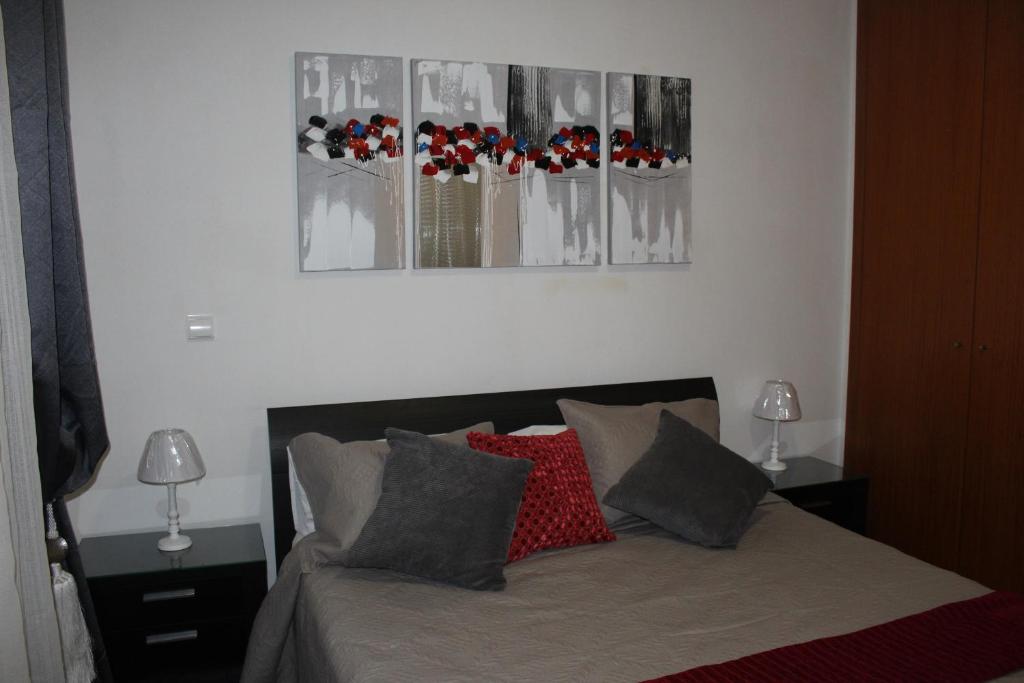 丰沙尔Uptown Madalenas的卧室配有一张墙上三幅照片的床