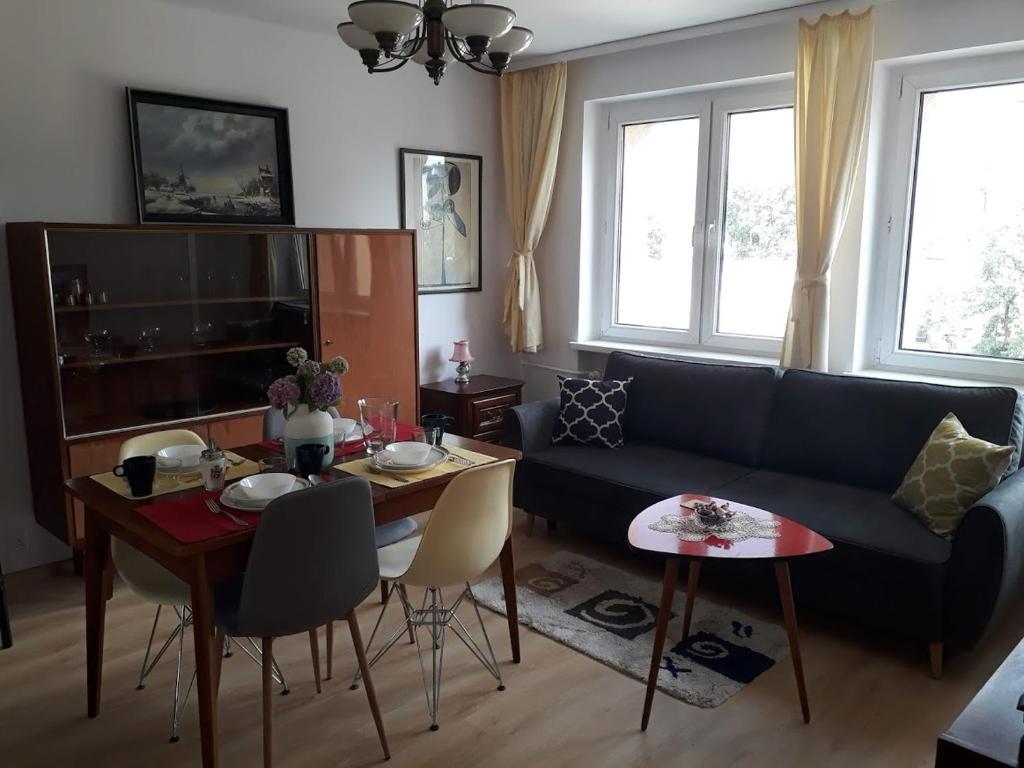 卡托维兹Modern retro apartament Katowice的客厅配有蓝色的沙发和桌子