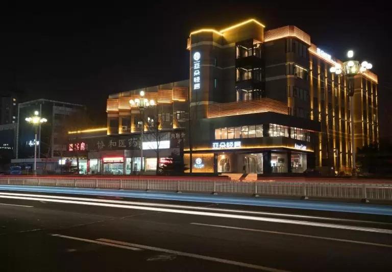 唐山唐山会展中心亚朵轻居酒店的一座晚上在前面有街道的建筑
