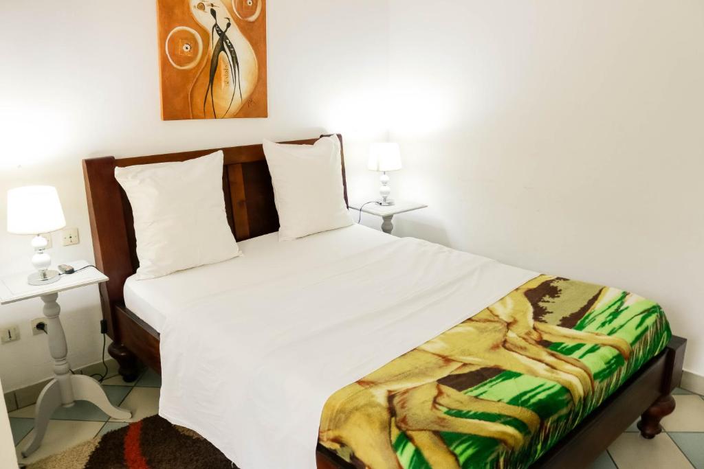 杜阿拉Tchero Appartement 1的一间卧室配有一张带白色床罩的床