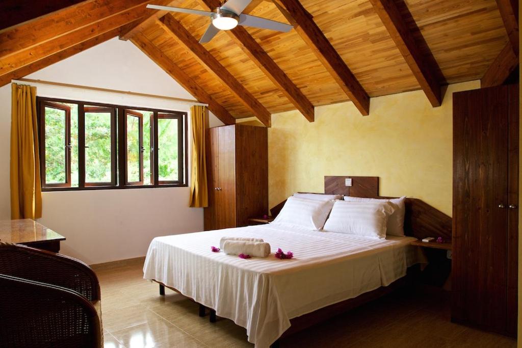 安西沃尔伯特村Villa Sole的一间卧室配有一张大床和吊扇