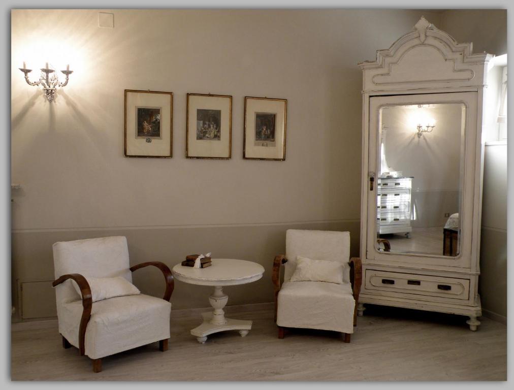 MelazzoCascina Luvot的配有桌子、两把椅子和镜子的房间