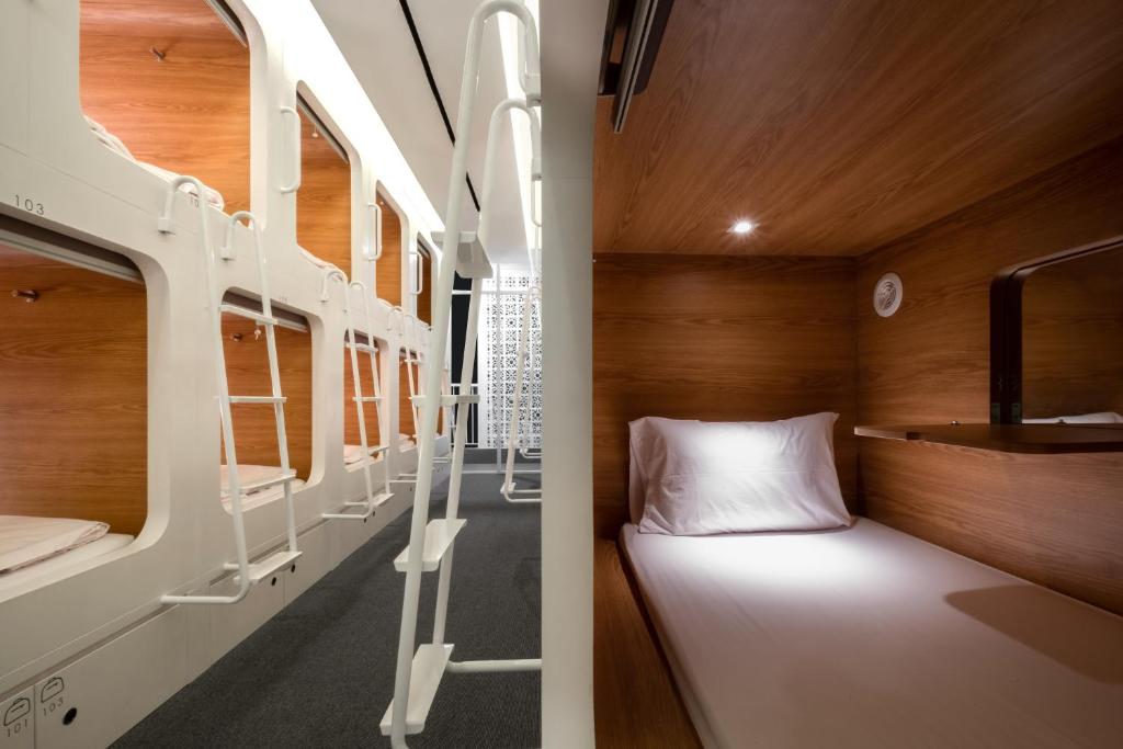 雅加达基尼胶囊旅馆的一间带一张双层床的卧室和一间带一张双层床的双层床间