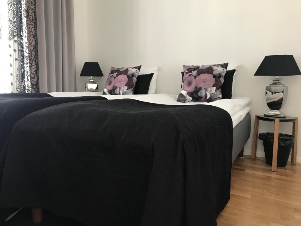 波里Antintorni Suite 17的一间卧室配有两张带黑色毯子和枕头的床。