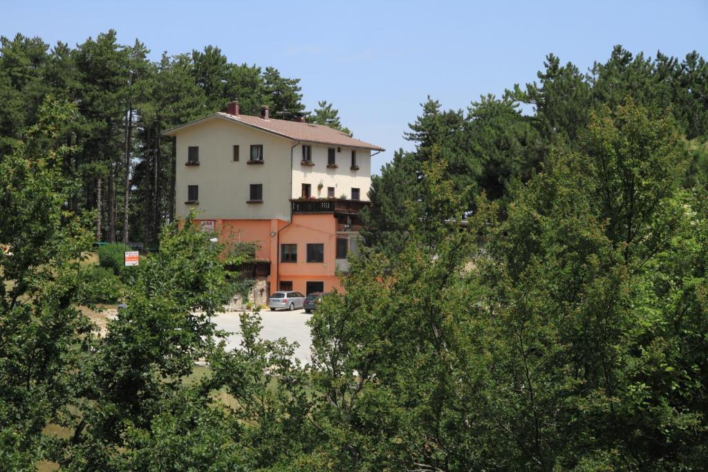 罗卡拉索B & B La Pineta By La Capannina的树木中间的白色大建筑