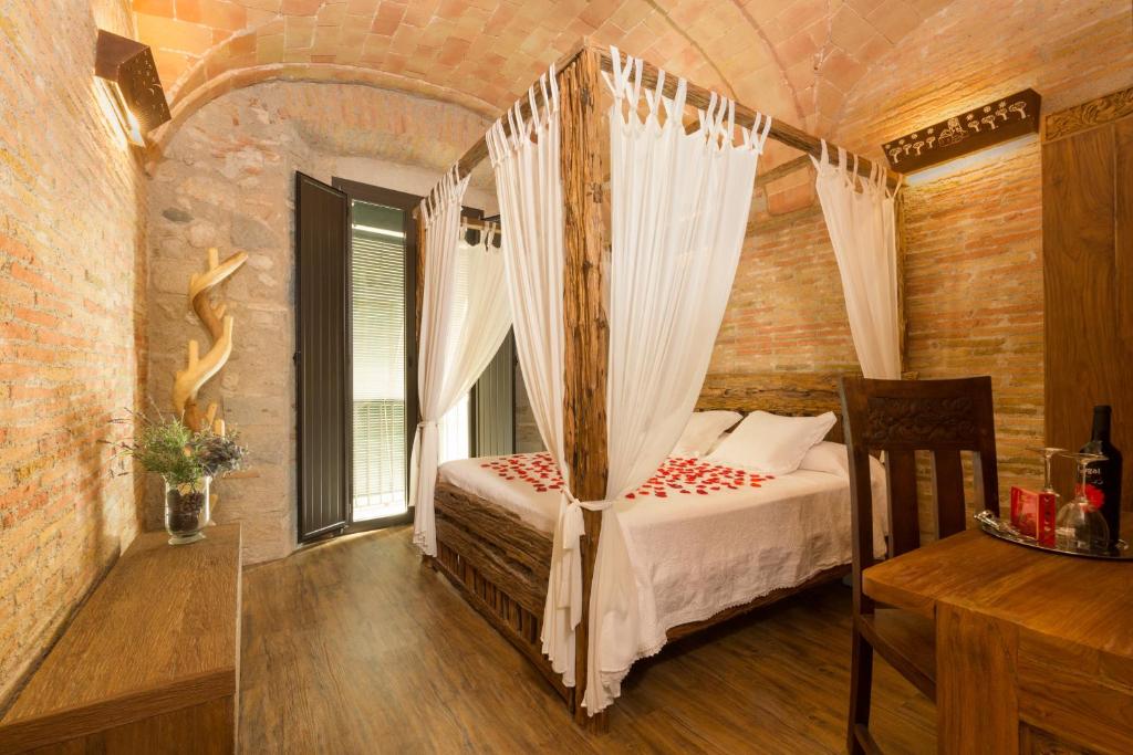 赫罗纳西斯托里克酒店的一间卧室,卧室内配有一张天蓬床