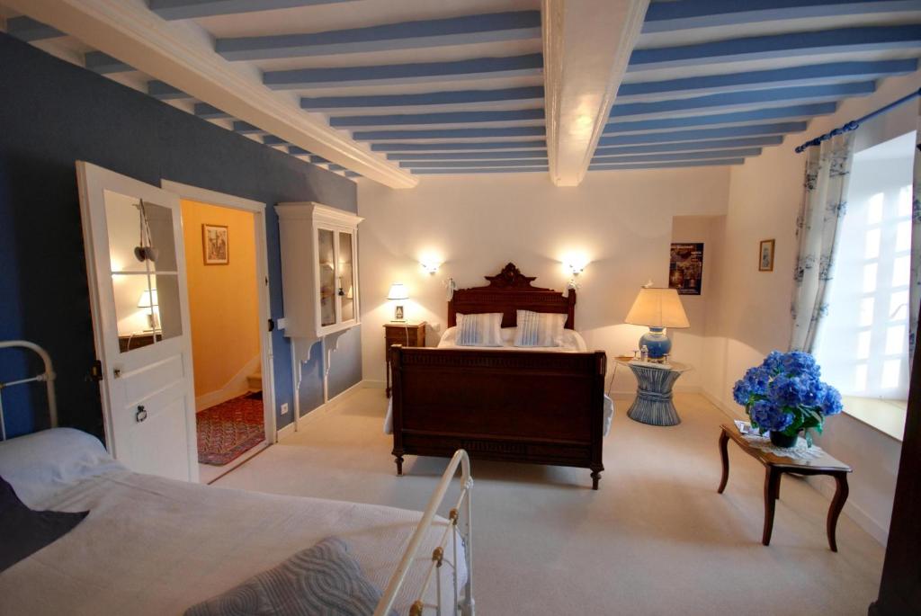 格朗德康迈西La Faisanderie的一间设有床铺的卧室,位于蓝色天花板的房间