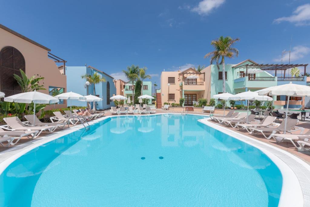 马斯帕洛马斯维斯塔塞里娜俱乐部酒店的一个带椅子和遮阳伞的大型游泳池