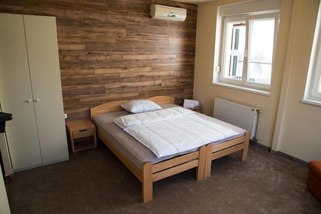 诺维萨德Vege & Vegan Restaurant and Accommodation的一间卧室设有一张床和木墙