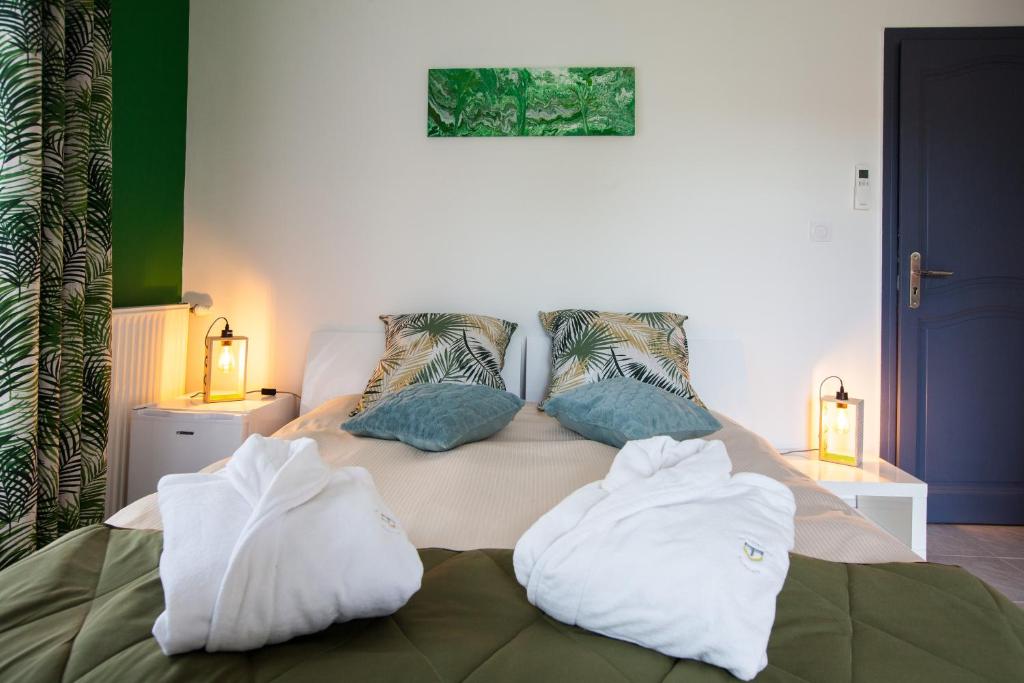 尼姆Les villas du triangle - chambres d'hôtes的床上有两条白色毛巾