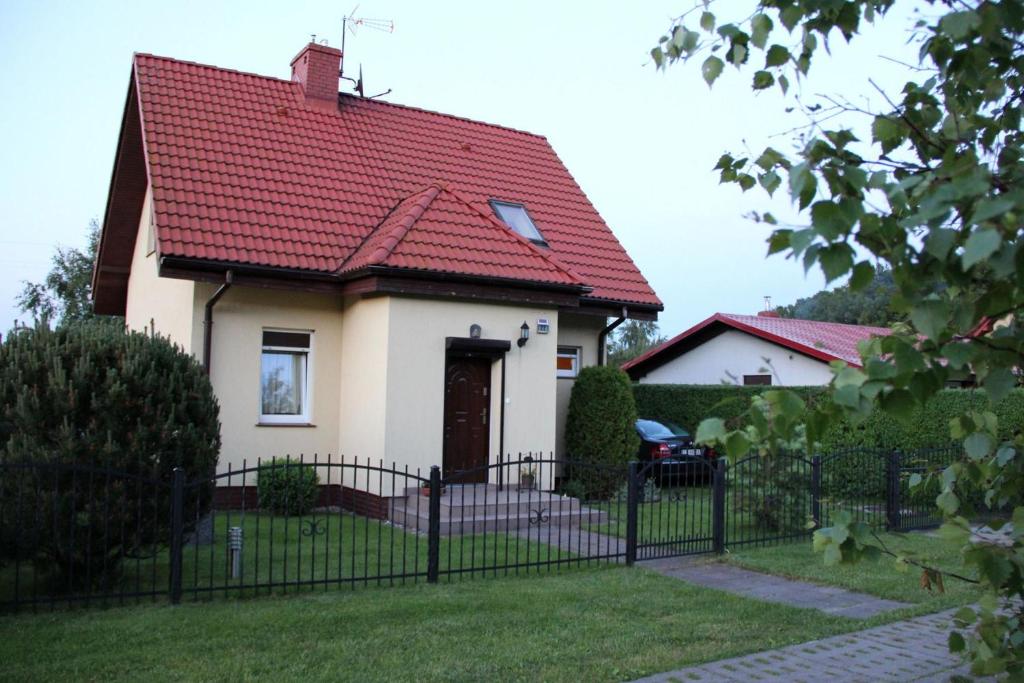 鲁斯诺沃Całoroczny dom nad morzem的一间白色的小房子,有红色的屋顶