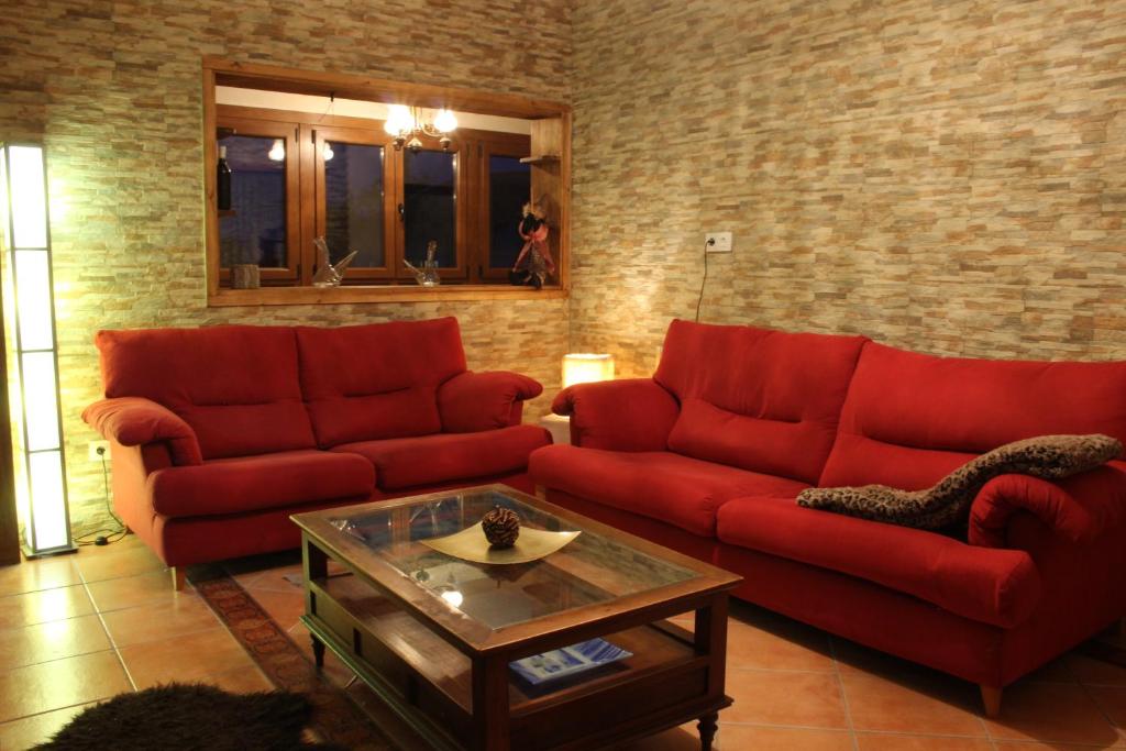 索尔波Casa do Bouza Vello的客厅配有两张红色的沙发和一张桌子