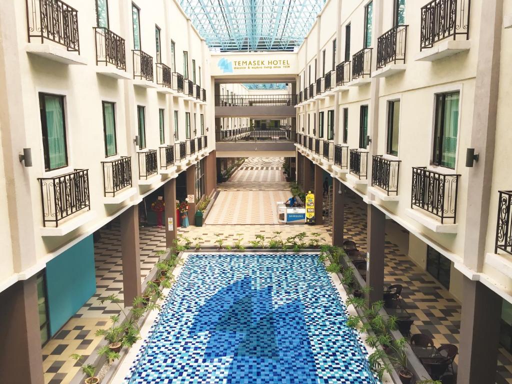 马六甲淡马锡酒店 的享有带游泳池的大楼的顶部景致