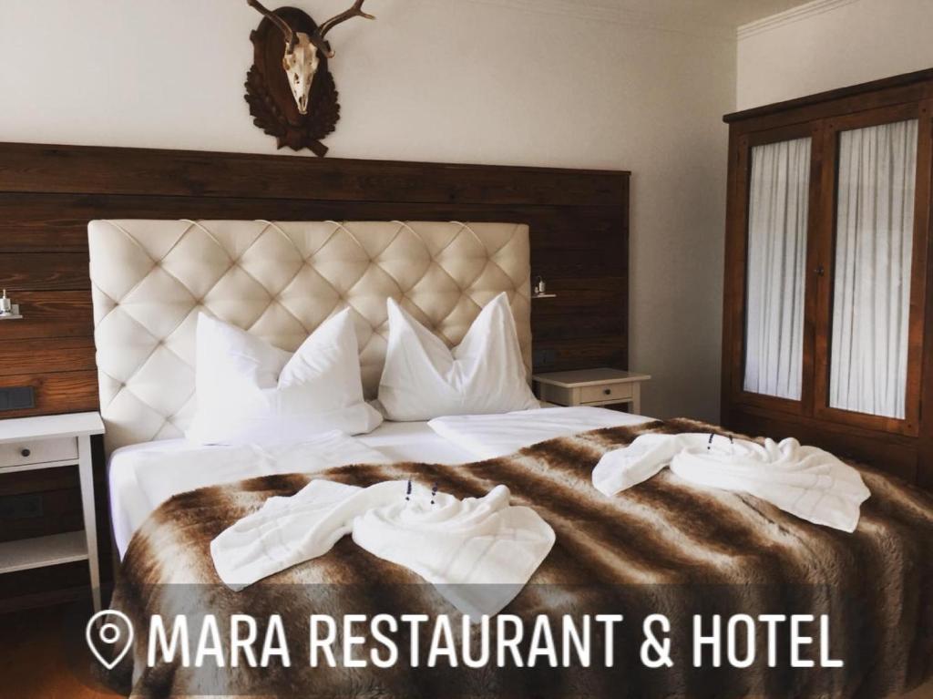 迪森阿姆阿梅尔塞Mara Restaurant & Hotel的酒店客房,配有一张大床,上面有两双鞋