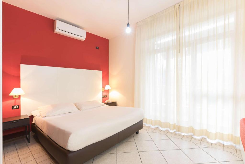 巴里Hotel La Baia的卧室配有白色的床和红色的墙壁