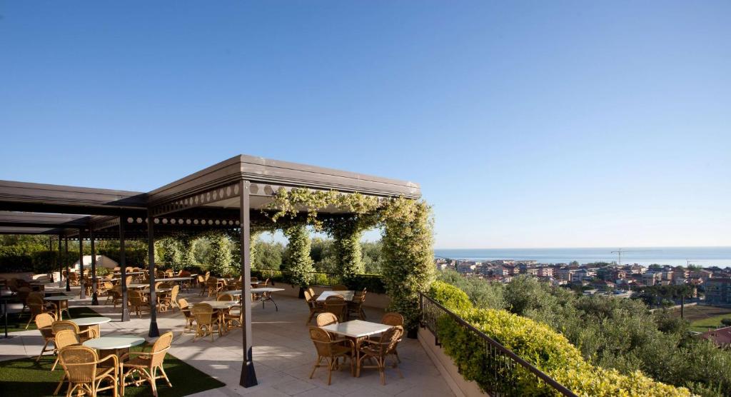 滨海弗兰卡维拉Villa Maria Hotel & SPA的庭院内的餐厅,配有桌椅