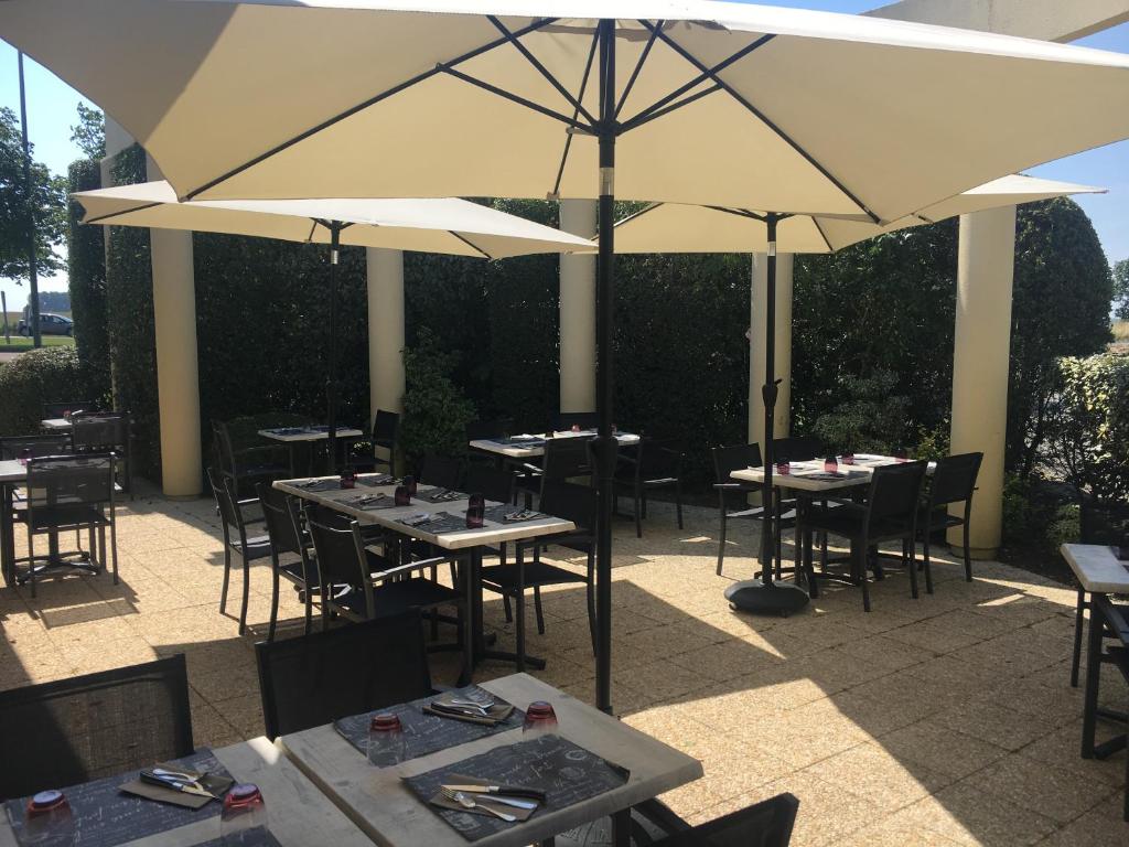博尔贝克埃特雷塔酒店的庭院内的餐厅,配有桌子和遮阳伞