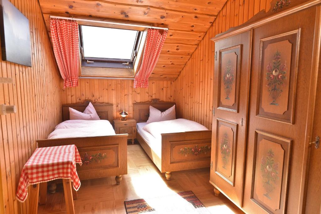 拜尔里舍艾森施泰恩Ferienwohnung Waldheimat的小房间设有两张床和窗户