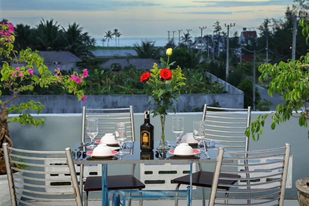 会安Hoi An Sea Sunset Homestay and Bar的一张桌子,上面放着一瓶葡萄酒和鲜花