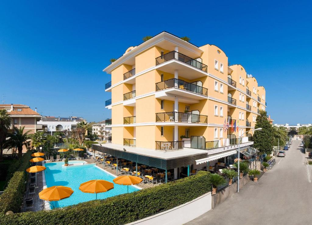 圣贝内代托-德尔特龙托尹朋里亚酒店的一座带游泳池和橙色遮阳伞的酒店