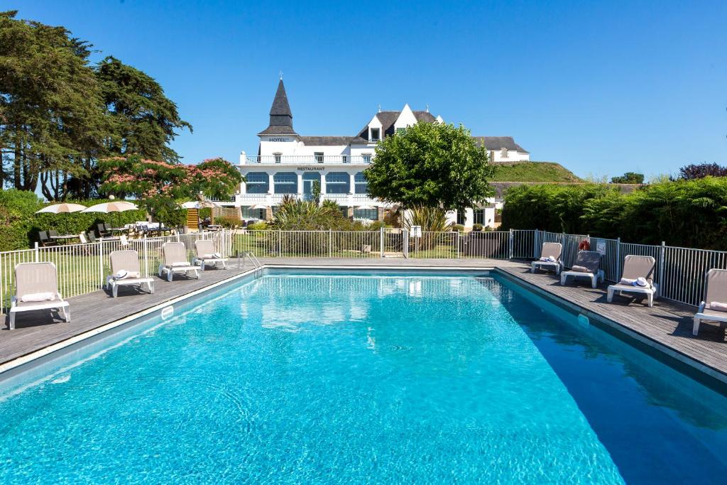卡纳克Hotel Restaurant Spa du Tumulus Carnac的一个带椅子的游泳池和一个背景房子